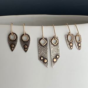 three pairs of modern love style earrings displayed in a row