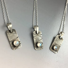 three small pendants in a row with rainbow moonstones