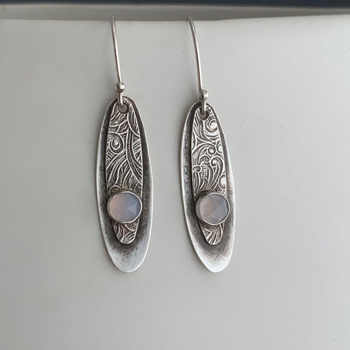silver earrings with swirly patterns